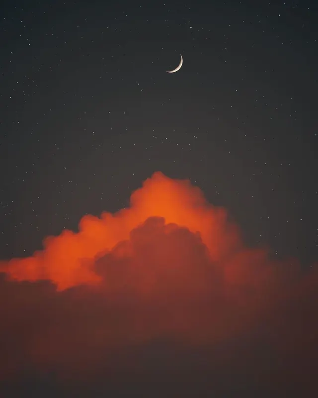A burning orange cloud under a crescent moon